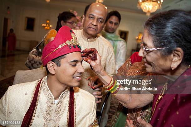 indian woman marking groom's face - indian wedding ceremony photos et images de collection