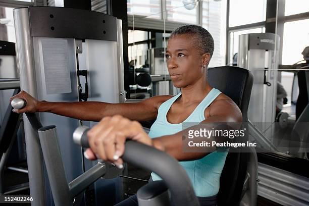 african american woman exercising in health club - trainingsmaschine stock-fotos und bilder