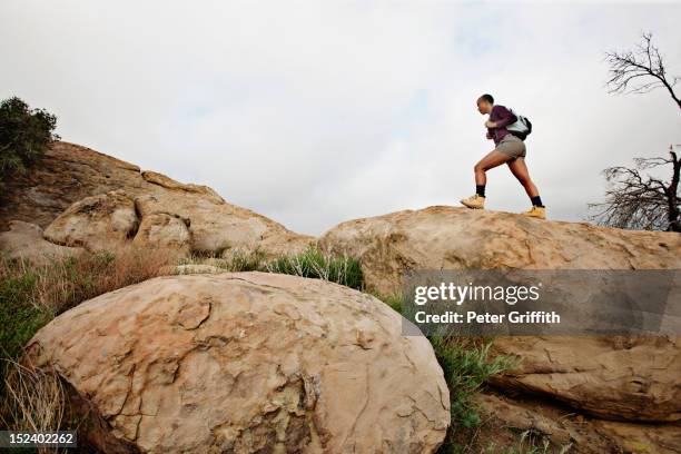 black woman hiking on rocks - african american hiking stock-fotos und bilder