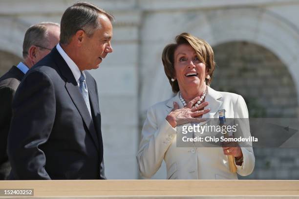 House Minority Leader Nancy Pelosi reacts after Speaker of the House John Boehner finishes driving her nail with one stroke during the "First Nail"...