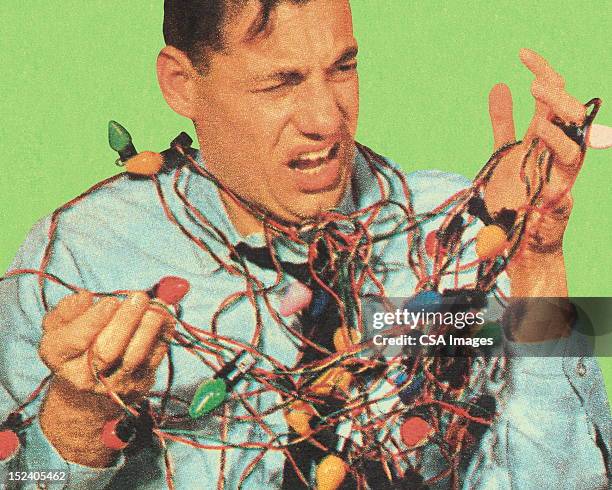 man with tangled christmas lights - electrical overload stockfoto's en -beelden