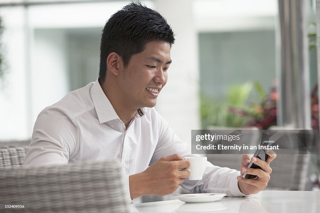 Businessman holding coffee cup and smartphone