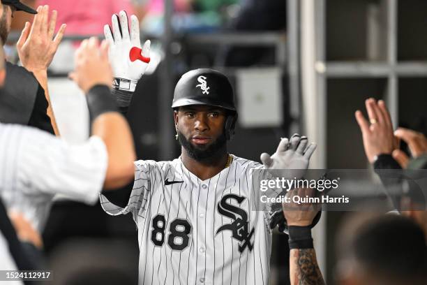 Luis Robert Jr. #88 of the Chicago White Sox celebrates in the dugout with teammates after his home run in the seventh inning against the St. Louis...