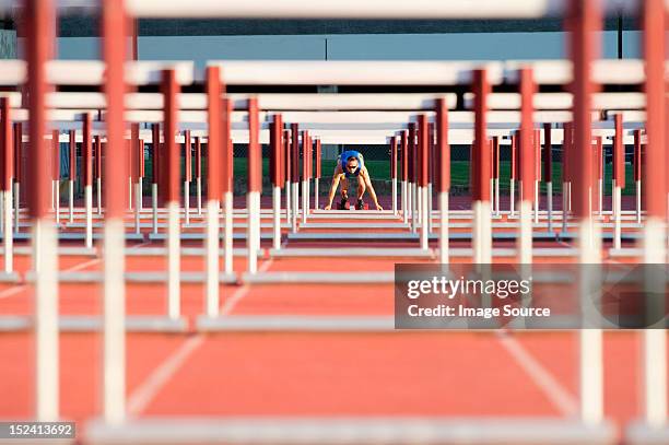 male hurdler at starting line - hurdle stock-fotos und bilder