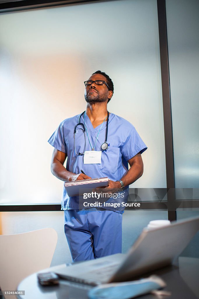 Doctor leaning on wall in office