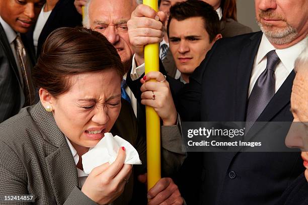 businesswoman sneezing on subway train - crowded train stock pictures, royalty-free photos & images