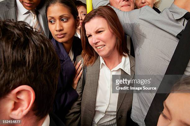 woman and man with sweaty armpit on crowded subway train - huddle foto e immagini stock