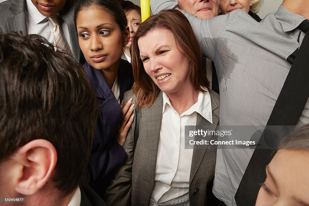 Woman and man with sweaty armpit on crowded subway train