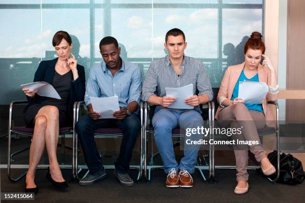 four people sitting on chairs with documents - candidate stock pictures, royalty-free photos & images