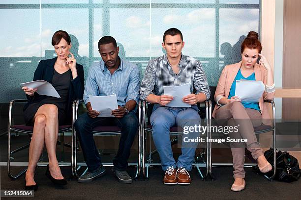 four people sitting on chairs with documents - candidate 個照片及圖片檔