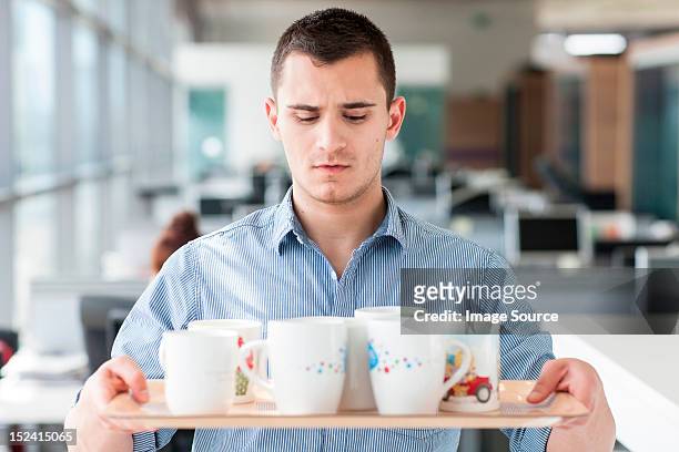 nervous looking man carrying tray of mugs - dag 1 stockfoto's en -beelden