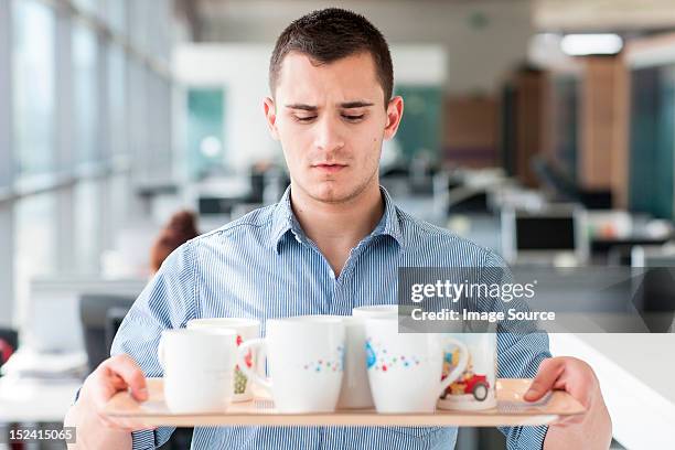 nervous looking man carrying tray of mugs - men bulge imagens e fotografias de stock