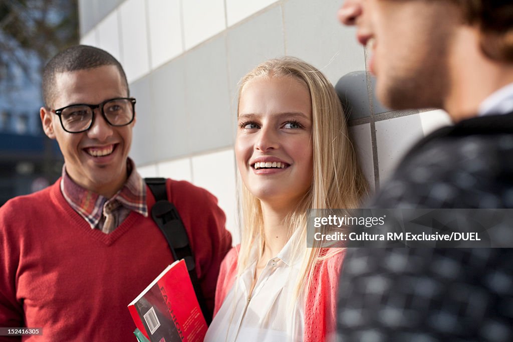 Smiling friends talking on city street