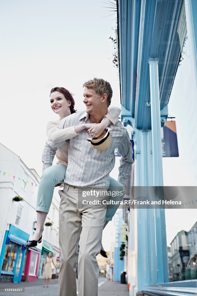 Man carrying girlfriend on city street