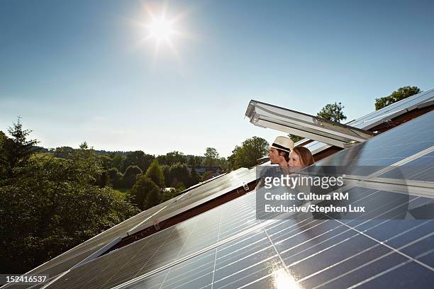 couple peering out of solar panel roof - solar panel stock pictures, royalty-free photos & images