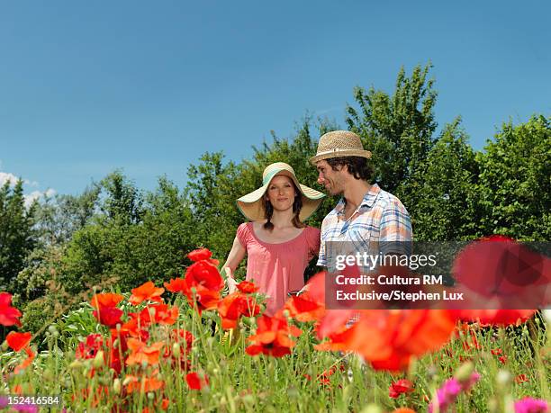 couple standing together in garden - blue white summer hat background stock pictures, royalty-free photos & images