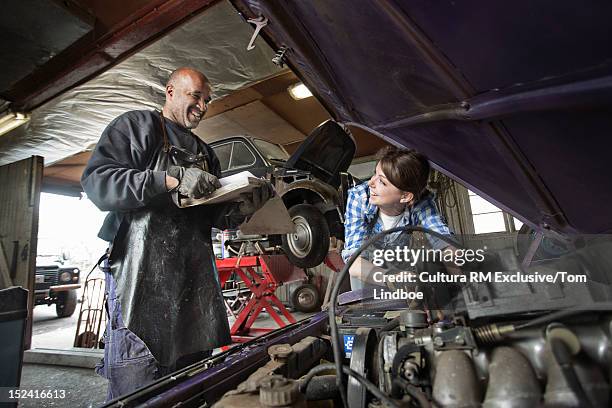 mechanics working on car in garage - leitwarte stock-fotos und bilder