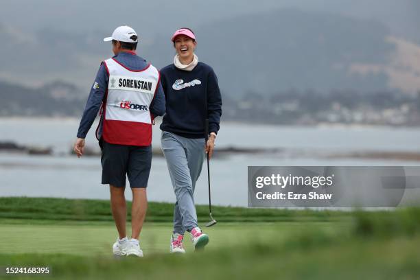 Michelle Wie West of the United States reacts with caddie Mike McGee fter making her long putt for par on the 18th green during the second round of...