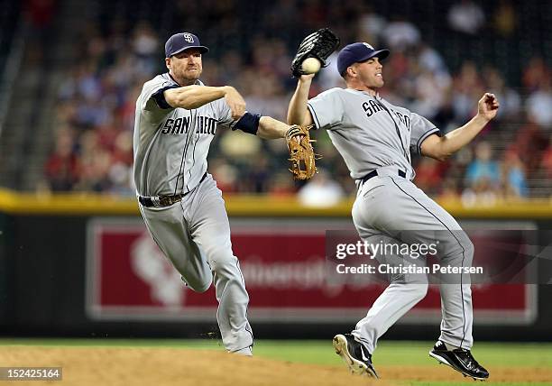 Infielder Chase Headley of the San Diego Padres fields a ground ball as he avoids contact with pitcher Clayton Richard during the MLB game against...