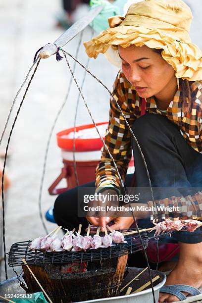 a local street vendor roasts squid over a grill. - matthew calamari foto e immagini stock