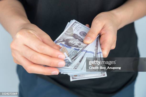 cropped shot of someone hands holding and counting american dollar banknotes in hands. - banknote stock pictures, royalty-free photos & images