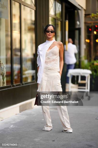 Chriselle Lim wears black sunglasses from Fendi, gold embossed cut-out logo earrings from Fendi, a white wool scarf, a white embossed lace pattern...
