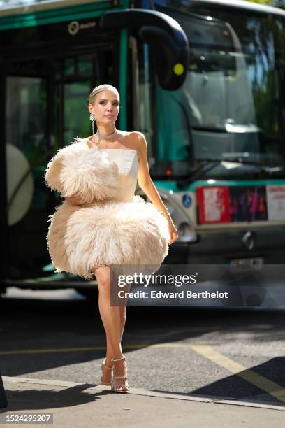 Leonie Hanne wears a diamonds large rose flower with fringe pendant earring, a large diamonds necklace, a white latte shoulder-off / corset top /...