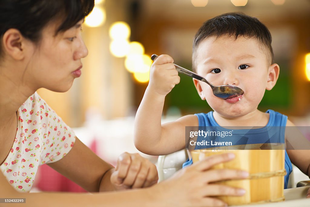 Boy eats lunch with big wooden bowl