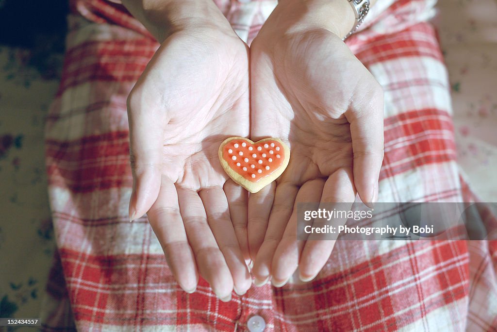 Woman holding heart-shaped biscuits