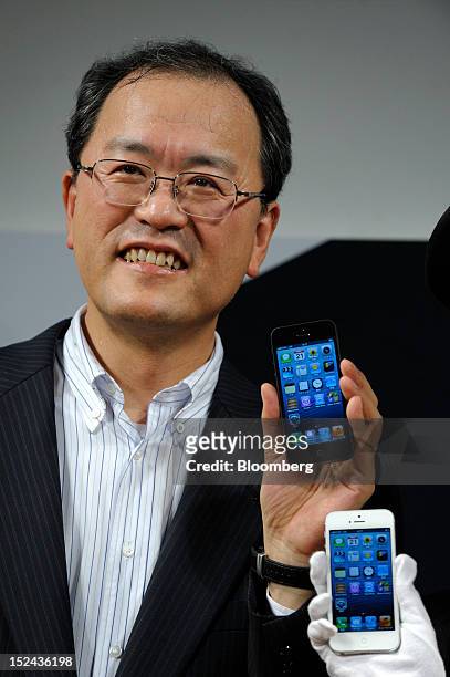 Takashi Tanaka, president of KDDI Corp., poses with an Apple Inc. IPhone 5 in Tokyo, Japan, on Friday, September. 21, 2012. Apple is poised for a...