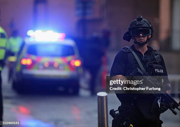 Police officer stands guard as Dale Cregan arrives in an armed convoy to face charges of murder and attempted murder at Manchester City Magistrates'...