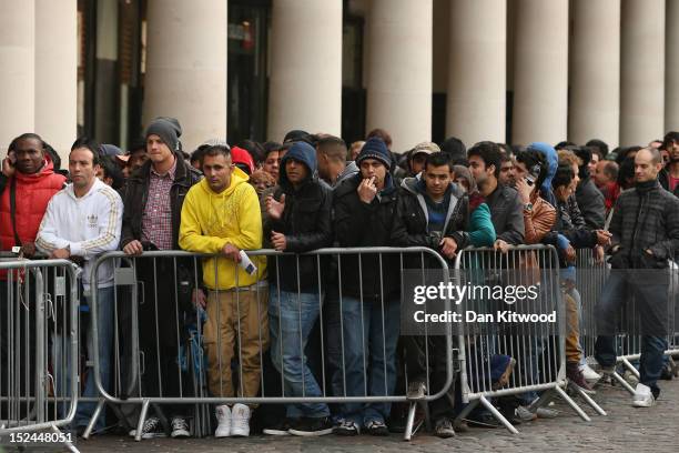 People queue outside the Apple store in Covent Garden to purchase the iPhone 5 smartphone on September 21, 2012 in London, England. The much...