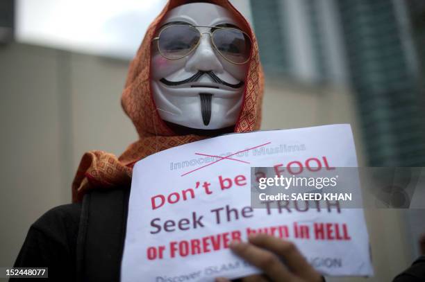 Protestor wearing a scarf holds a placard in front of the US embassy during a rally against an anti-Islam film, "Innocence of Muslims" and the...