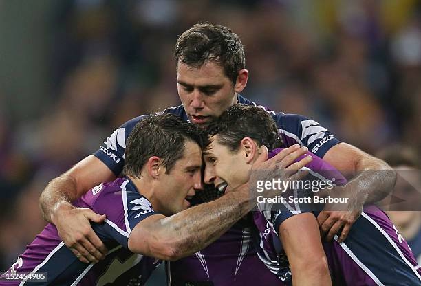 Cameron Smith and Cooper Cronk congratulate Billy Slater of the Storm after he scored a try in the second half during the NRL Preliminary Final match...