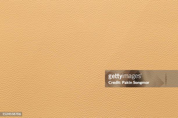 light brown leather and a textured background. - rindsleder stock-fotos und bilder