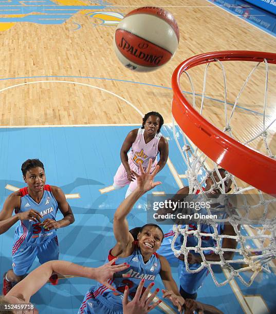 Arminte Price of the Atlanta Dream goes to the basket past teammate Angel McCoughtry and Carolyn Swords and Epiphanny Prince of the Chicago Sky on...