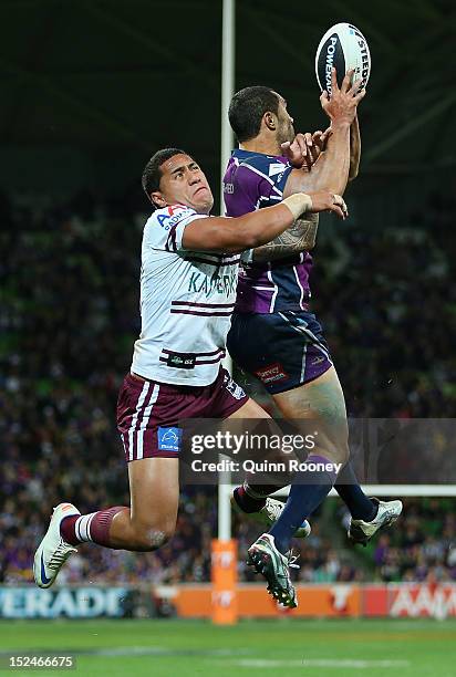 Jorge Taufua of the Sea Eagles and Justin O'Neill of the Storm compete to catch a ball during the NRL Preliminary Final match between the Melbourne...