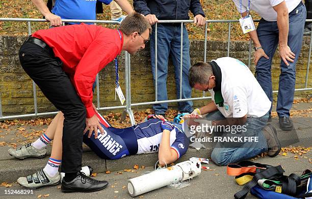 France's Eva Mottet is helped by her father Charly Mottet after she fell during the women's Junior Road race World Championships on September 21 in...