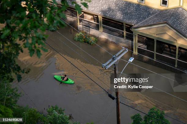 In an aerial view, a kayaker paddles through the flooded waters of Elm Street on July 11, 2023 in Montpelier, Vermont. Up to eight inches of rain...