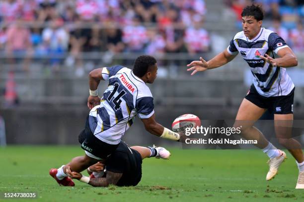 Jone Naikabula of Japan XV offloads the ball during the international test between Japan XV and All Blacks XV at Prince Chichibu Memorial Ground on...