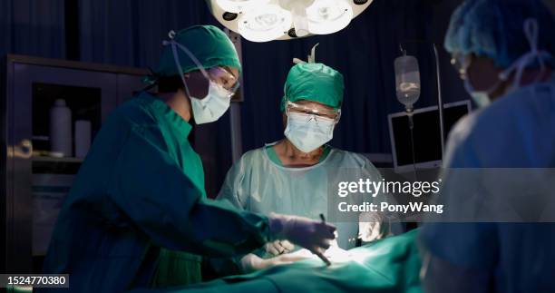 surgeons in hospital operating room - medical procedure stock pictures, royalty-free photos & images