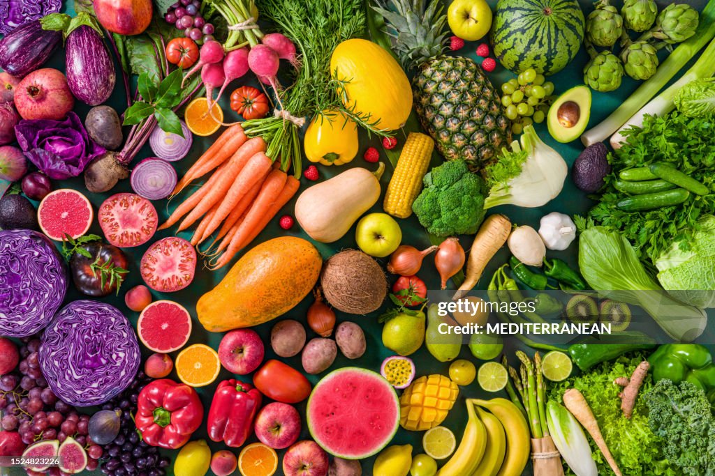 Colorful raw fruits and vegetables varied vegan food, vivid rainbow arrangement