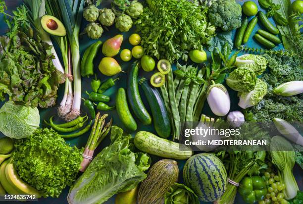 frutas y verduras crudas comida vegana en mesa verde monocromática full frame - dieta a base de plantas fotografías e imágenes de stock