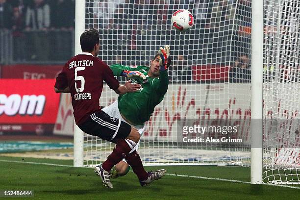 Goalkeeper Kevin Trapp of Frankfurt makes a save ahead of Hanno Balitsch of Nuernberg during the Bundesliga match between 1. FC Nuernberg and...