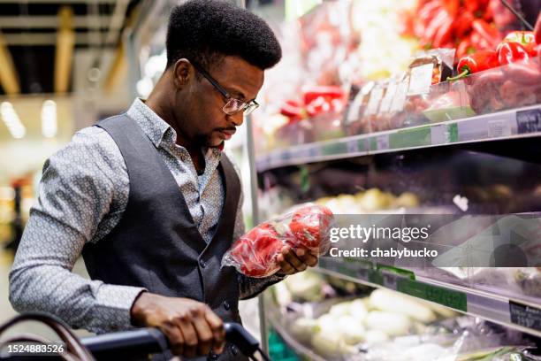 man compares products in supermarket - food state stock pictures, royalty-free photos & images