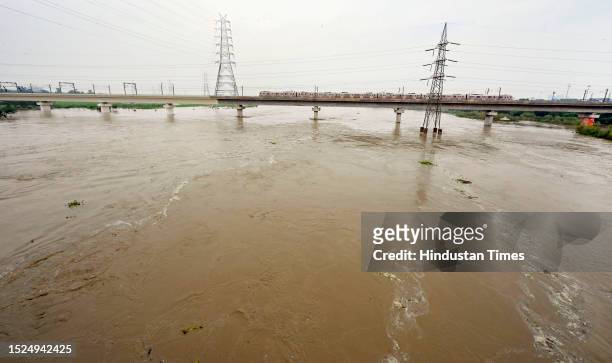The swollen Yamuna river flows in full spate under the Delhi Metro Bridge on July 11, 2023 in New Delhi, India.