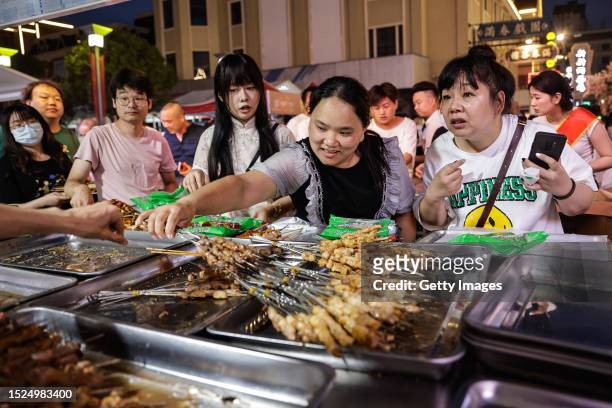 Tourists enjoy a barbecue at Hankou town during Zibo first barbecue festival Tour on July 7, 2023 in Wuhan, Hubei province, China. The organizer has...