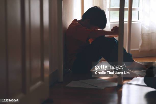 a sad and frustrated asian boy, burdened by schoolwork pressure refuses to go to school. - refusing stock pictures, royalty-free photos & images