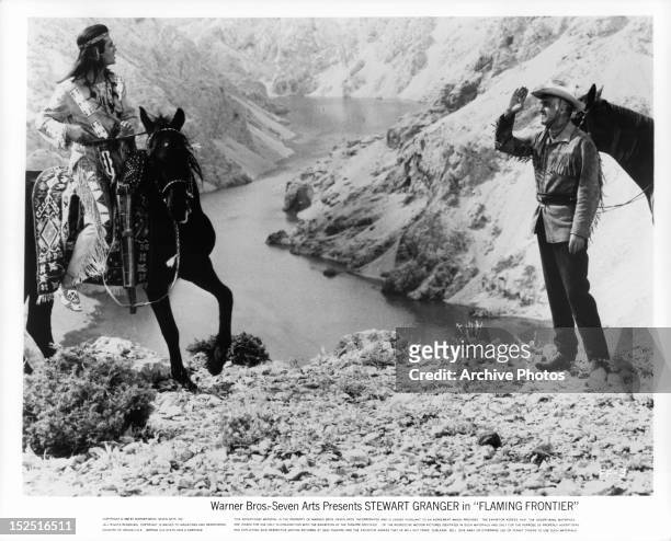 Pierre Brice pulling up on horseback to Stewart Granger in a scene from the film 'Flaming Frontier', 1965.