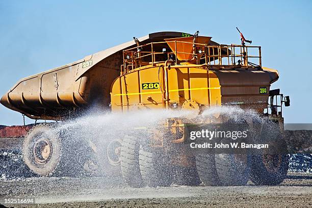 water truck spraying a road, kalgoorlie gold mine - banagan dumper truck stock pictures, royalty-free photos & images